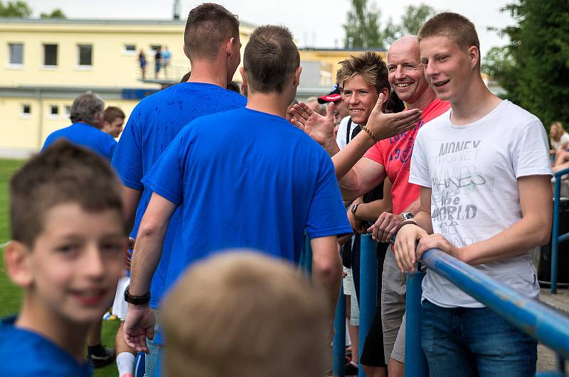 Ostrovští fotbalisté (v modrém) slavili po utkání s Královským Poříčím, které vyhráli 7:1, návrat do divizní soutěže.