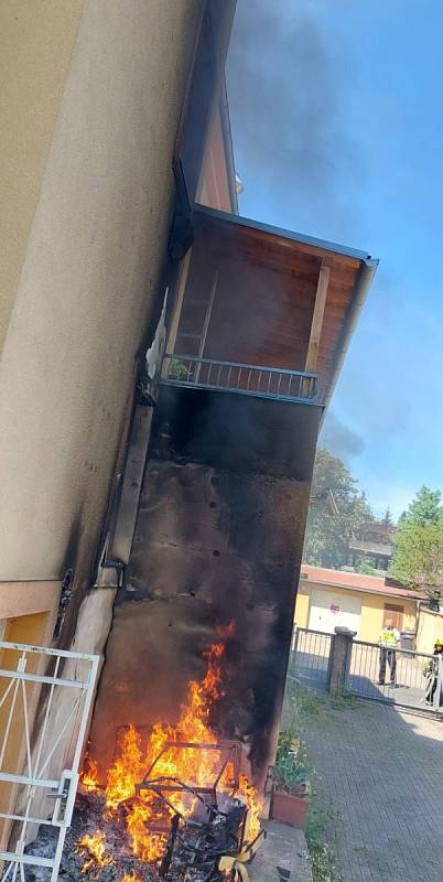 Požár odpadu u domu v karlovarské části Rybáře, při kterém hasiči evakuovali obyvatele domu za pomoci výškové techniky.