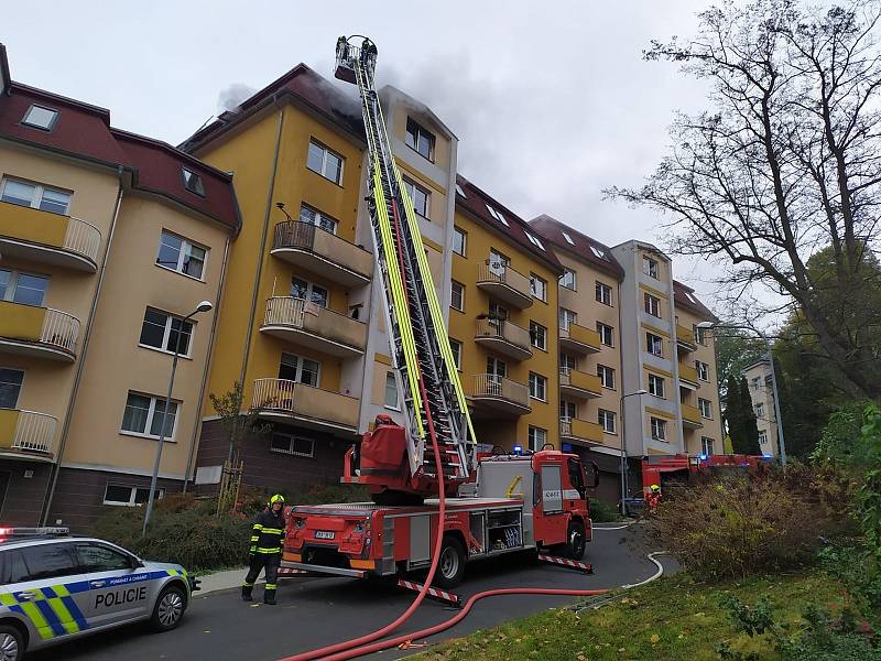 Hasiči zasahují v karlovarské části Drahovice u požáru bytu v posledním patře bytového domu.