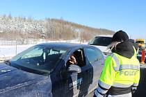 První den uzávěry okresů Cheb a Sokolov. Policisté kontrolují řidiče na D6 za obcí Hory.