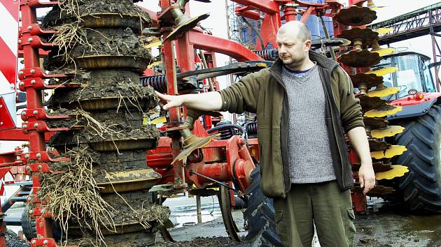 ŘEDITEL STATKU BOR Vladimír Matějů ukazuje nánosy bahna na strojích, které ztěžují práci zemědělcům. 