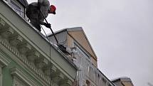 Odstraňování rampouchů a sněhových převisů ze střech domů v na třídě T. G. Masaryka v centru Karlových Varů.