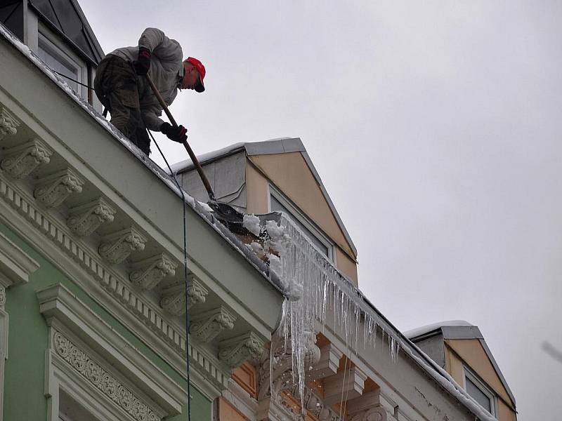 Odstraňování rampouchů a sněhových převisů ze střech domů v na třídě T. G. Masaryka v centru Karlových Varů.