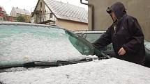 První sníh motoristům radost neudělal. Řada z nich ještě ani nepřezula auta na zimní gumy. Na snímku odklízí sníh z auta řidič v Kraslicích.