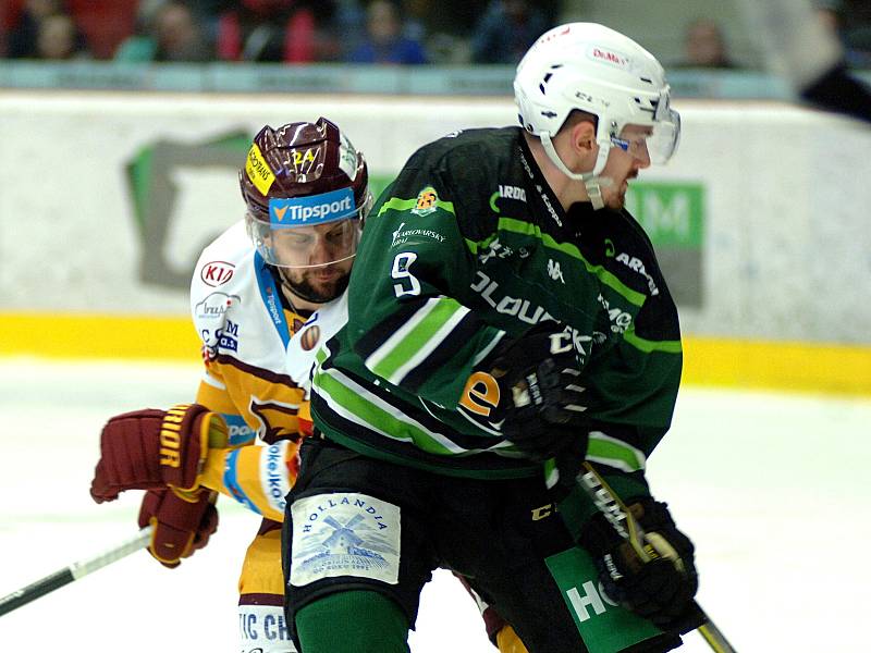 Hokejisté HC Energie (v zeleném) hostili Jihlavu. Filip Seman atakuje Jakub Fleka