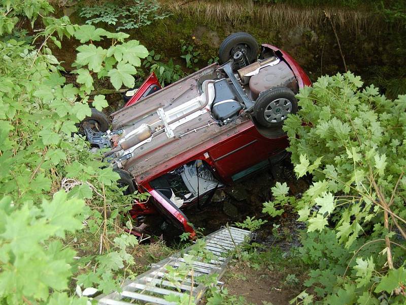 Srážka dvou automobilů v Jáchymově. Jeden z vozů po kolizi narazil do stromu, druhé auto se zřítilo do potoka.