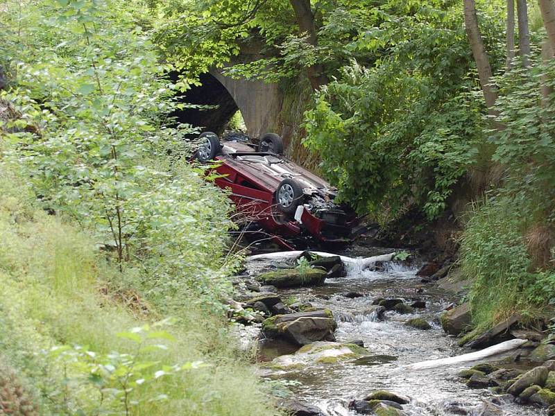 Srážka dvou automobilů v Jáchymově. Jeden z vozů po kolizi narazil do stromu, druhé auto se zřítilo do potoka.