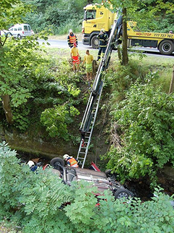 Srážka dvou automobilů v Jáchymově. Jeden z vozů po kolizi narazil do stromu, druhé auto se zřítilo do potoka.