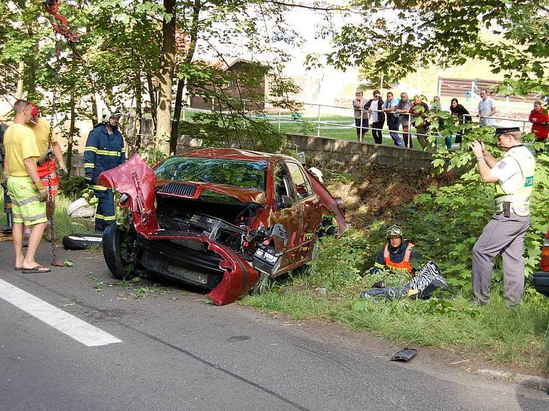 Srážka dvou automobilů v Jáchymově. Jeden z vozů po kolizi narazil do stromu, druhé auto se zřítilo do potoka.