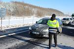 První den uzávěry okresů Cheb a Sokolov. Policisté kontrolují řidiče na D6 za obcí Hory.