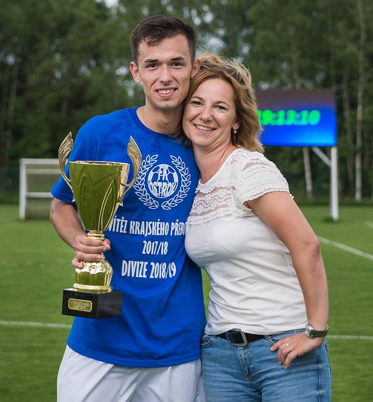 Ostrovští fotbalisté (v modrém) slavili po utkání s Královským Poříčím, které vyhráli 7:1, návrat do divizní soutěže.