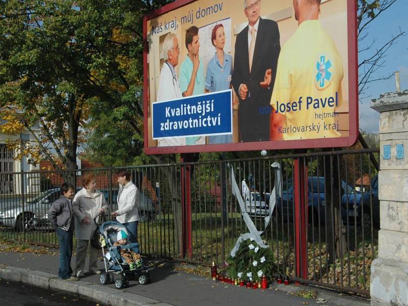 Tryzna za zdravotnictví. Před billboardem s Josefem Pavlem (ODS), který visí u karlovarské nemocnice, se začátkem tohoto týdne objevily svíce a věnec.