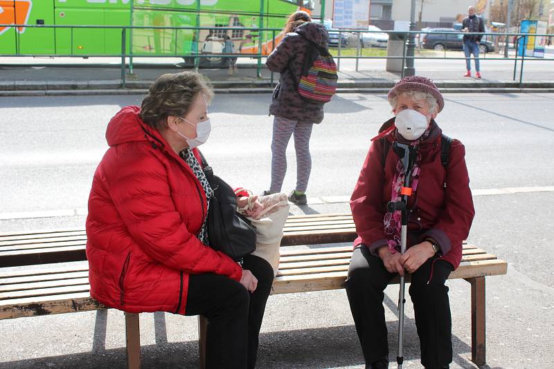 Jen málokdo už vyjde do ulic bez ochrany. Kdo nemá roušky, chrání se šátky či nákrčníky. Řada lidí ale stále vstupuje do autobusů nechráněna.