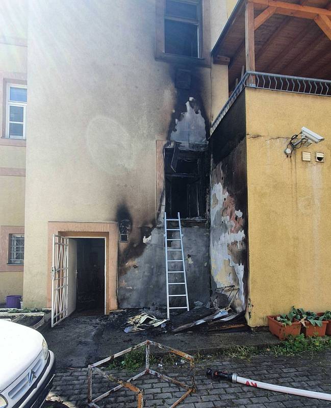 Požár odpadu u domu v karlovarské části Rybáře, při kterém hasiči evakuovali obyvatele domu za pomoci výškové techniky.