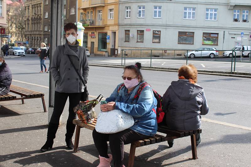 Jen málokdo už vyjde do ulic bez ochrany. Kdo nemá roušky, chrání se šátky či nákrčníky. Řada lidí ale stále vstupuje do autobusů nechráněna.