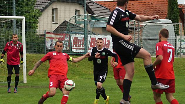 Votický kapitán Jakub Šlejmar (v červeném) odpaluje míč ve Vestci z vlastní šestnáctky. 