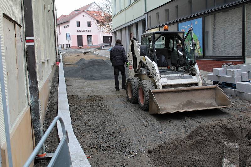 Závěrečné fázi rekonstrukce vodovodu a kanalizace v ulici Na Karlově v Benešově, pokládce žulové dlažby, předchází zhutnění podloží.