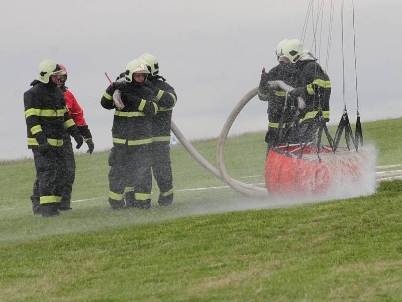 Dobrovolní hasiči trénovali doplňování vaku zavěšeném pod vrtulníkem pro hašení požárů v nepřístupném terénu. 