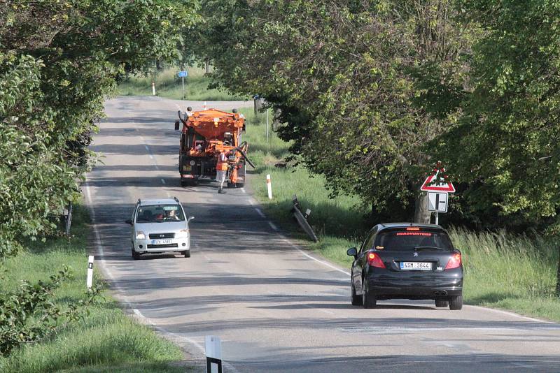 Výsprava trhlin ve vozovce asfaltovou emulzí na silnici II/106 u odbočky na Bukovou Lhotu.