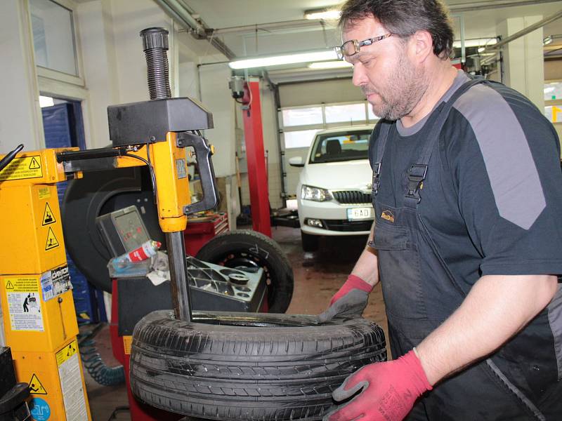 Pracovník benešovského servisu Best drive při nazouvání pneumatiky na ráfek.