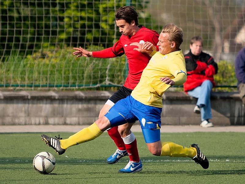 Benešovský Oldřich Komárek se snaží skluzem zastavit bývalého hráče Benešova Josefa Petličku, tentokrát v dresu Ostré. 