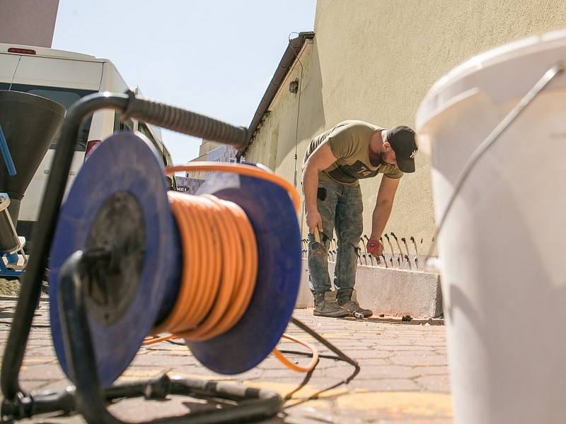 Práce při instalaci chemické hydroizolace na budově kina v Poštovní ulici v Benešově.