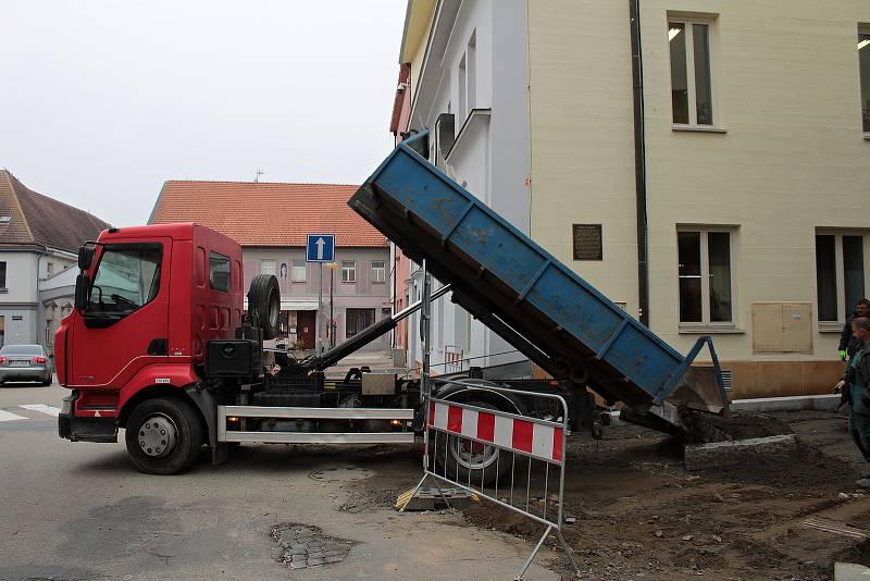 Závěrečné fázi rekonstrukce vodovodu a kanalizace v ulici Na Karlově v Benešově, pokládce žulové dlažby, předchází zhutnění podloží.