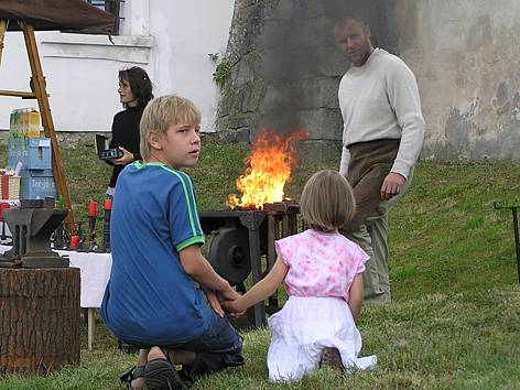 Kovář rozdělává oheň ve výhni