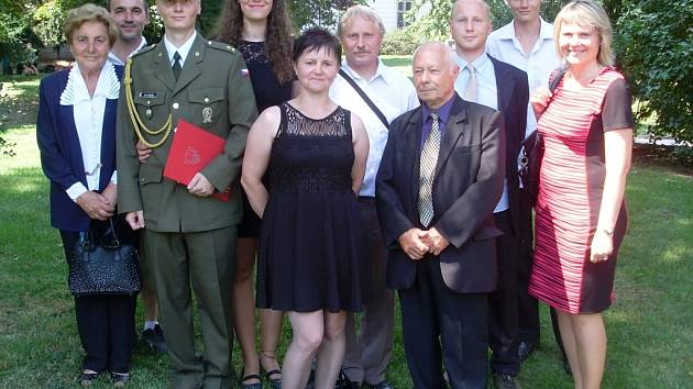 Jan Holub s rodinou a červeným diplomem absolventa Univerzity obrany.