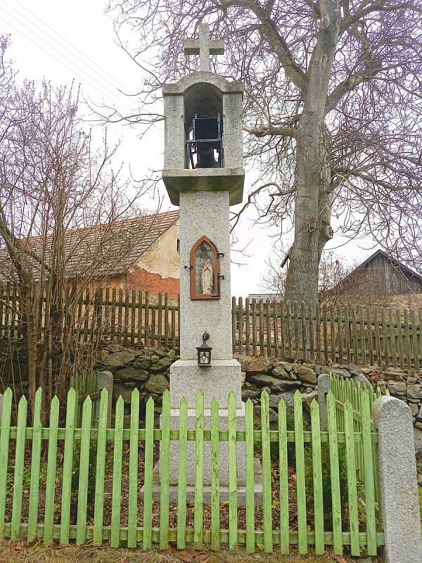 Z kamene tesaná zvonička z roku 1905 ve Veletíně, v jejiž přední části je zašpičatělý výklenek.
