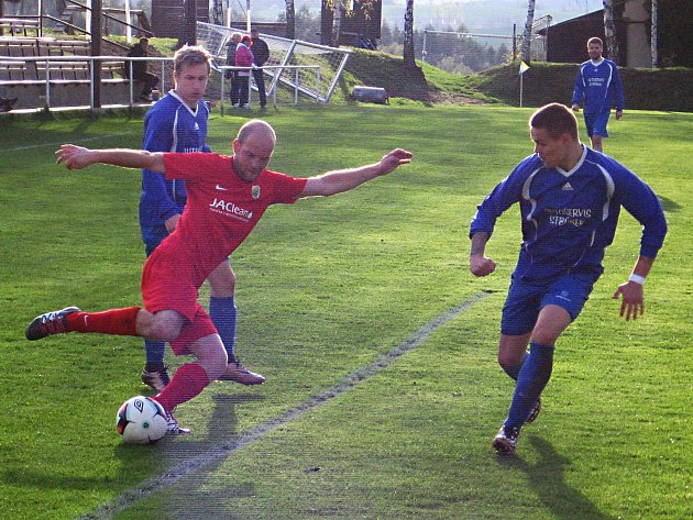 Kondracký Petr Sedláček (v červeném) centruje míč před týneckým Filipem Koptou (vpravo). 