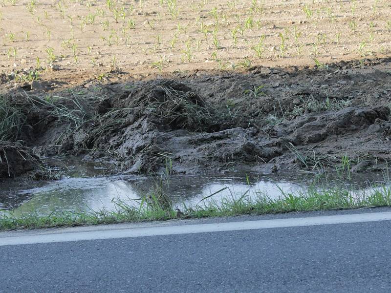 Voda z pole vytéká na vozovku už i po běžných deštích.