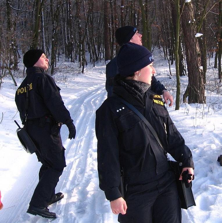 Rozcestí Pod Borkou. 12. ledna 10.20, policisté míří přes zasněženou louku k Borce, rekreačním objektům nedaleko Přestavlk u Čerčan