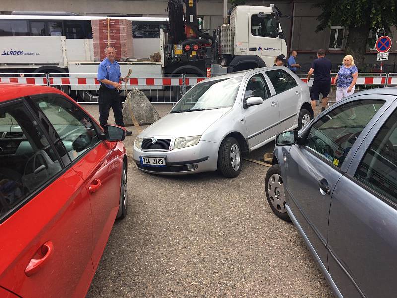 Auto uvízlé kolem v kanálové šachtě na parkovišti v Táborských kasárnách v Benešově.