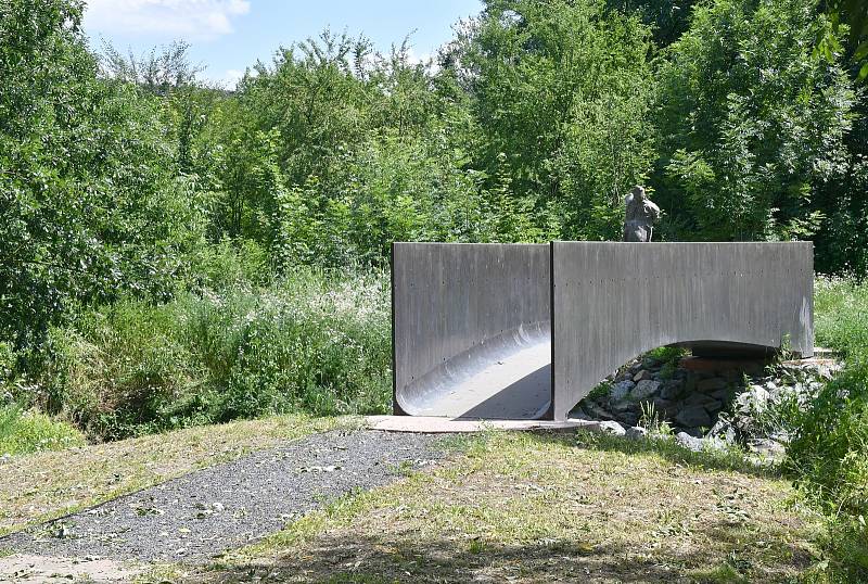 Lávka přes Dřetovický potok se sochou "Strážce lávky".