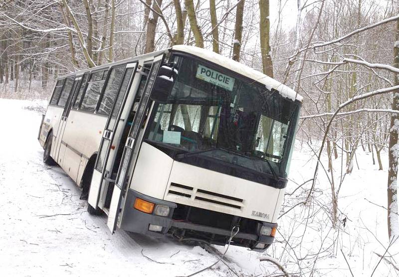 POLICEJNÍ AUTOBUS sjel na sněhu u vinařické střelnice mimo lesní cestu.