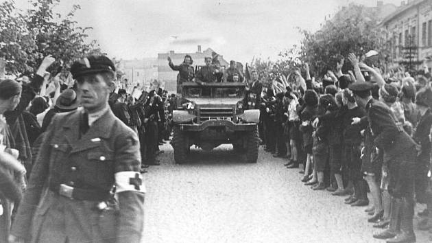 Sovětští vojáci na americkém obrněném transportéru vítaní v ulicích Kladna. 