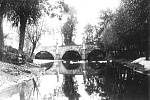 Fotografie z padesátých let minulého století. Před regulací Bakovského potoka protékala voda pod třemi oblouky mostu.