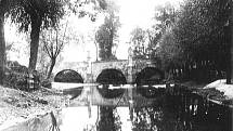 Fotografie z padesátých let minulého století. Před regulací Bakovského potoka protékala voda pod třemi oblouky mostu.