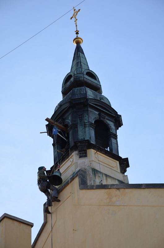 Snímání dvojice zvonů ve věži kaple Zasnoubení Panny Marie v piaristické koleji (dnešní budově muzea a knihovny) ve Slaném.