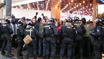 Policisté hlídají dav demonstrantů z řad anarchistů.