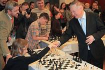 Anatolij Karpov si podává ruku na závěr partie s Matyášem Černíčkem // V Lidické galerii proběhla šachová simultánka mezi šachovými velmistry Anatolijem Jevgeněvičem Karpovem a Janem Smejkalem na jedné straně a 23 šachovými nadějemi z řad dětí  mládeže.