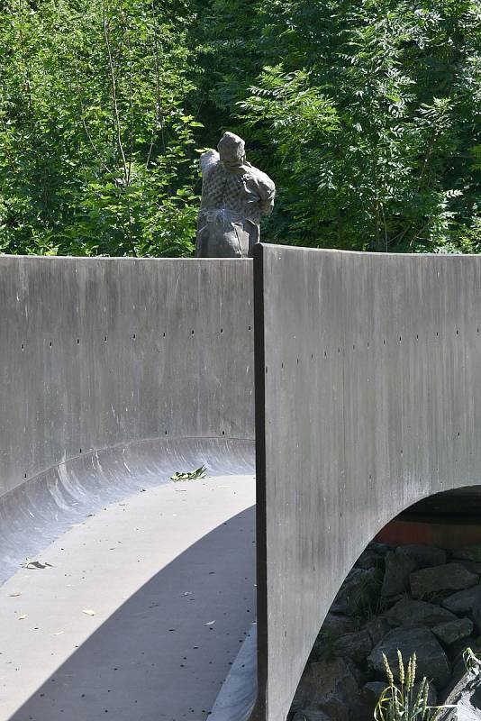 Lávka přes Dřetovický potok se sochou "Strážce lávky".