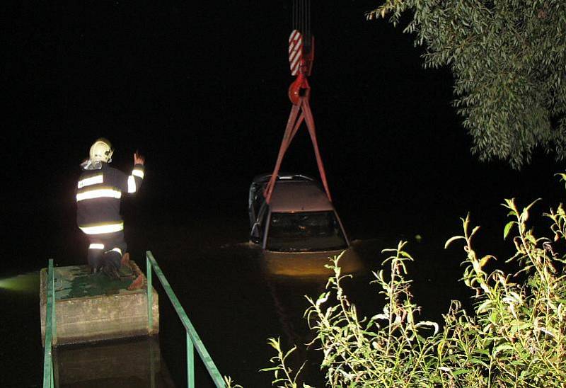 Hasiči tahají automobil utopený v rybníku Bucek.