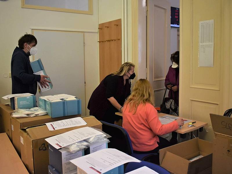 Zástupci škol ze Slánska si vyzvedávají sady testů na slánském úřadě.
