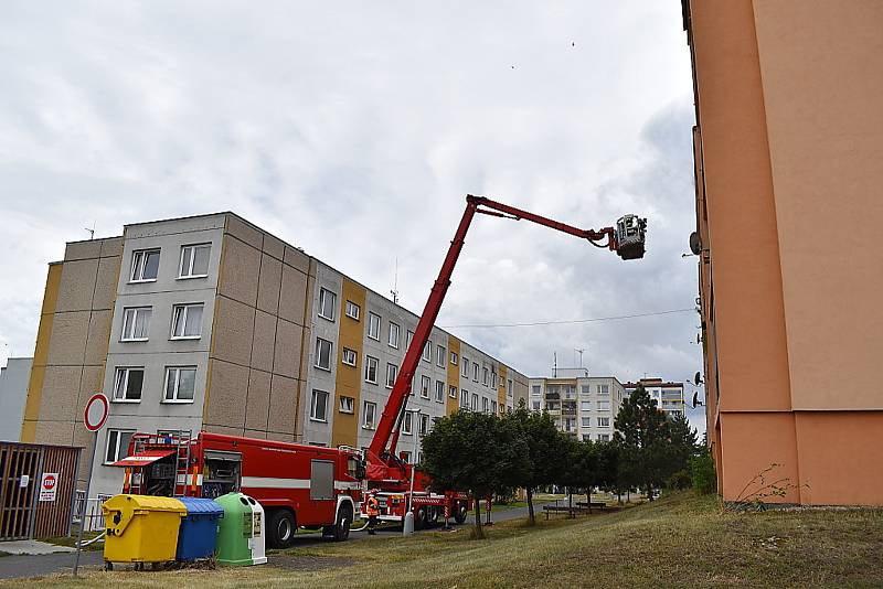 Ve Slaném hoří byt v paneláku, psa hasiči zachránili.