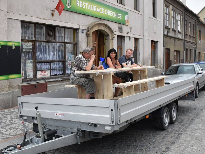 Aktivisté v Unhošti si přitáhli před restauraci valník. Na něm si vychutnávají pivo a cigaretu.