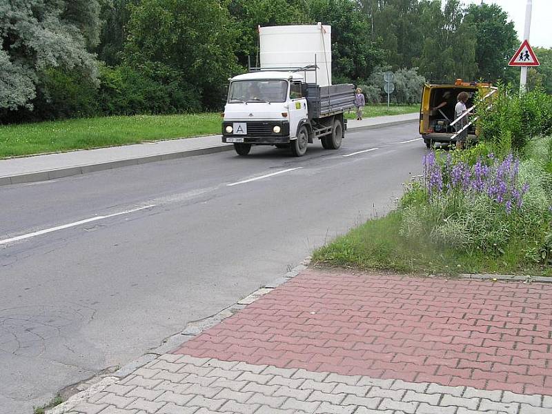 Silnice v rozdělovské Vašíčkově ulici připomíná spíše tankodrom. Příští rok bude kompletně opravena. Radní také plánují stavbu obchvatu, jenž by frekventované komunikaci ulehčil.