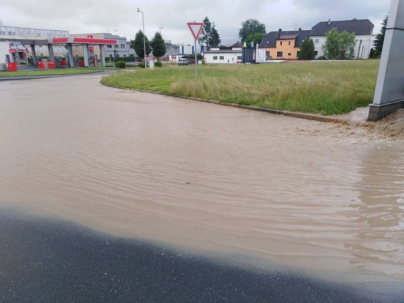 Zaplavená ulice v Klatovech u firmy Lorenc a Benziny ve směru na Luby. Voda teče proudem z pole.