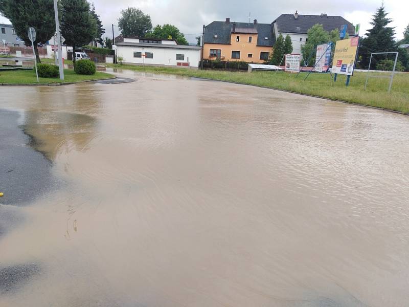 Zaplavená ulice v Klatovech u firmy Lorenc a Benziny ve směru na Luby. Voda teče proudem z pole.
